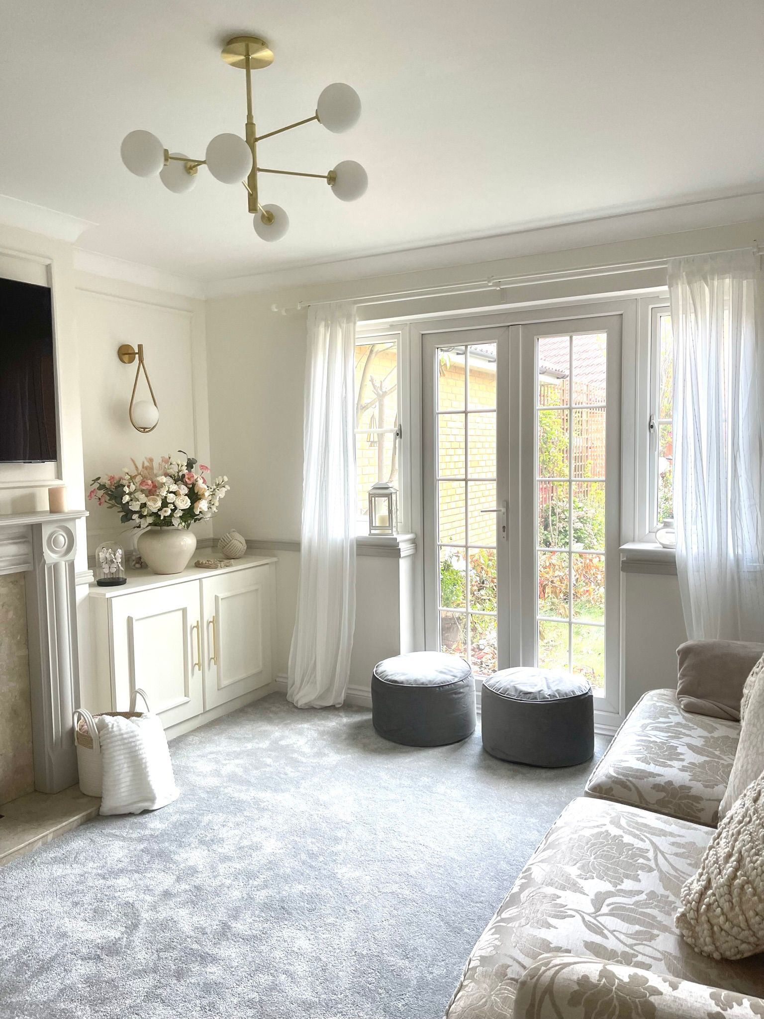 Living room interior design by Maison Zohora — warm cream tones, gold chandelier, French doors and considered styling