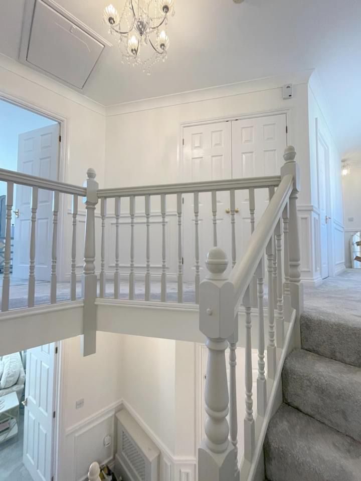 Staircase landing with white painted bannisters and crystal chandelier